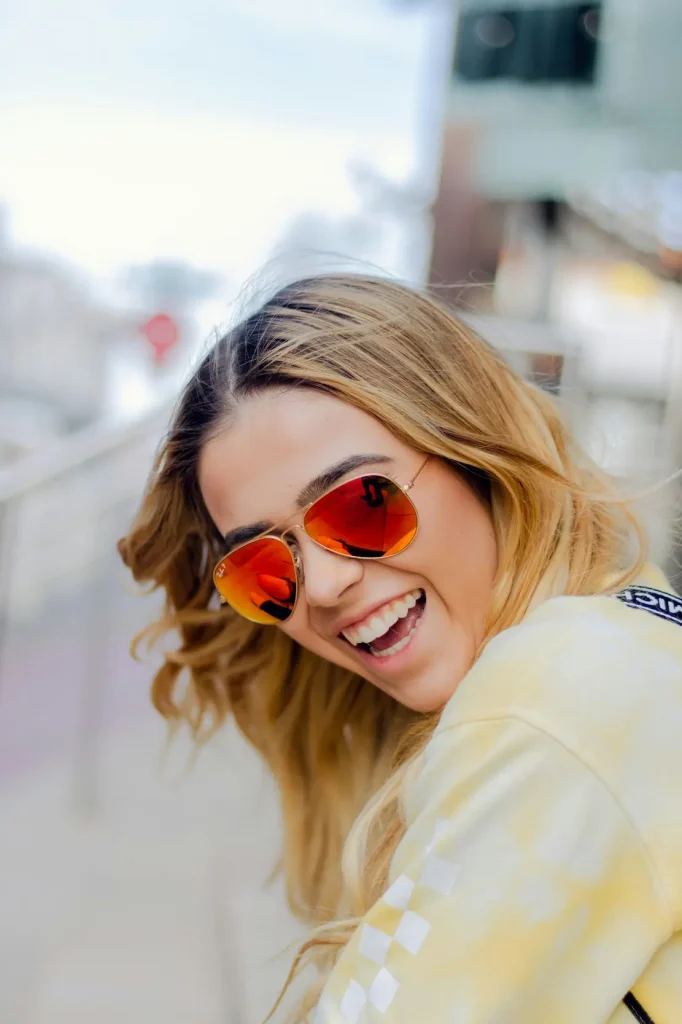 Femme heureuse portant des lunettes de soleil Ray Ban